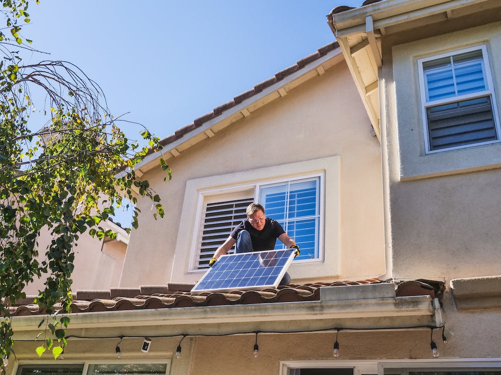 A man fitting domestic solar panels. Image by Kindel Media via Pexels