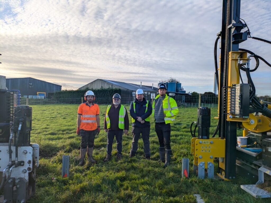 men stand in a field in high vis vests