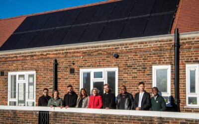 members of hackney council stand in front of a home with solar panels