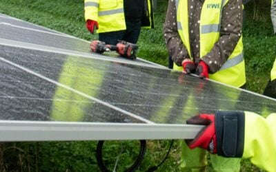 hands hold a solar panel with a drill on it