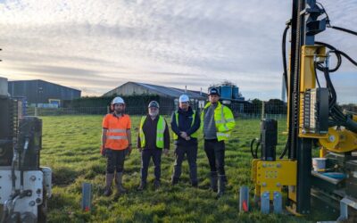 men stand in a field in high vis vests