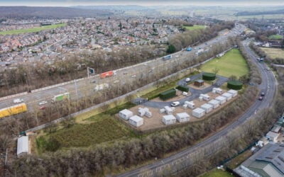 a 3d render of a BESS site next to a motorway