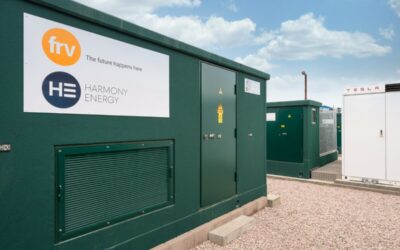 A dark green battery energy storage system, outside, under a blue sky