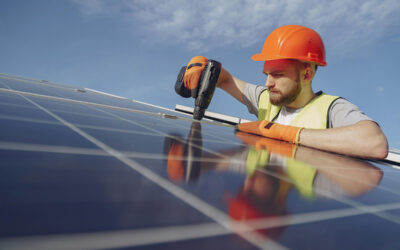 solar energy worker in hard hat and hi-vis installing solar PV modules