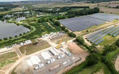 An aerial shot of a BESS and solar farm with trees surrounding it.