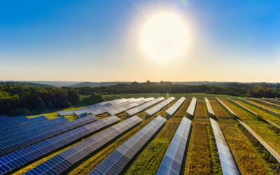 Image of rural solar farm with sun shining in the background