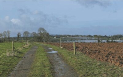 A country road with solar panels superimposed into the background