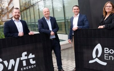 executives from bord gais and swyft shake hands while holding signs with company logos