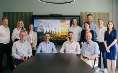 A group of people stand in front of the fidra energy logo